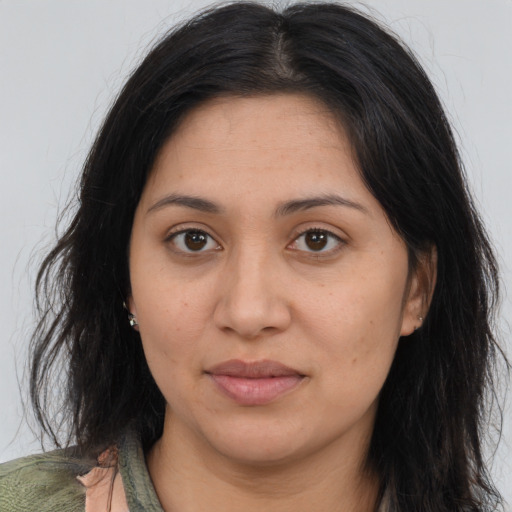 Joyful latino adult female with long  brown hair and brown eyes