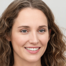 Joyful white young-adult female with long  brown hair and green eyes