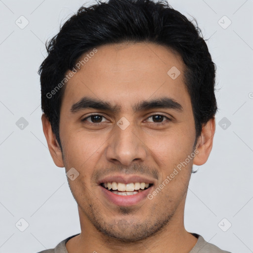 Joyful latino young-adult male with short  black hair and brown eyes