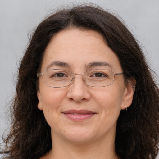 Joyful white adult female with long  brown hair and brown eyes