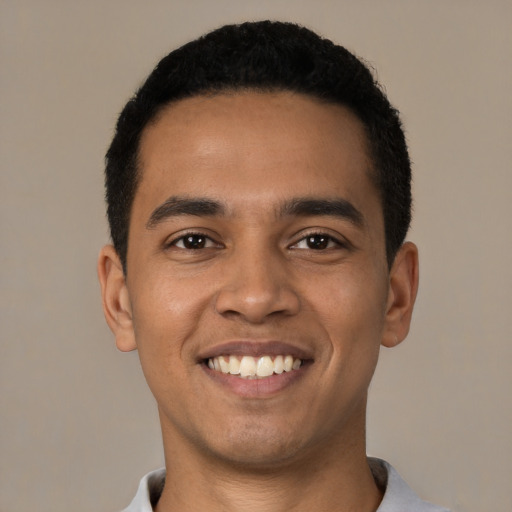 Joyful latino young-adult male with short  black hair and brown eyes