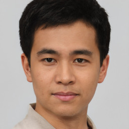 Joyful asian young-adult male with short  brown hair and brown eyes