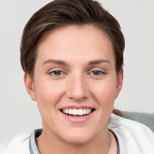 Joyful white young-adult female with short  brown hair and grey eyes