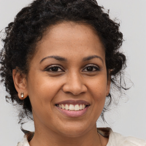 Joyful black young-adult female with medium  brown hair and brown eyes