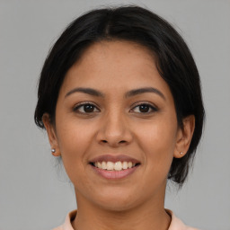 Joyful latino young-adult female with medium  brown hair and brown eyes