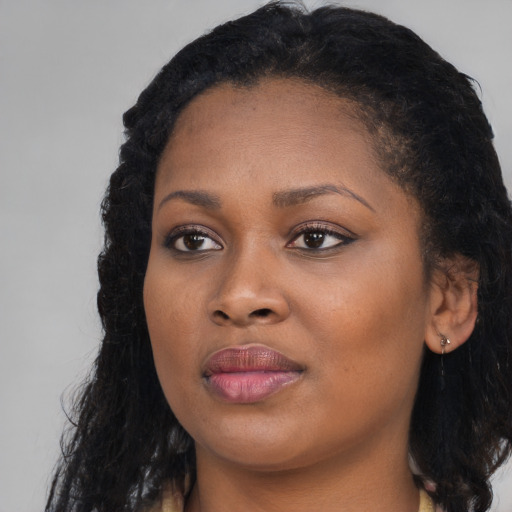 Joyful black young-adult female with long  black hair and brown eyes