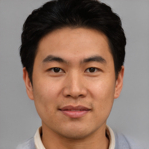 Joyful asian young-adult male with short  brown hair and brown eyes