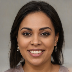 Joyful latino young-adult female with medium  brown hair and brown eyes