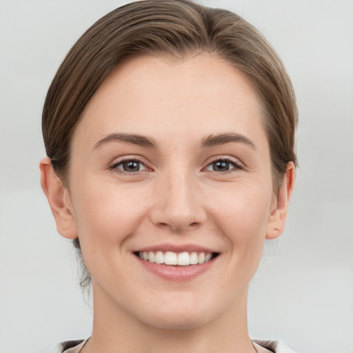 Joyful white young-adult female with short  brown hair and grey eyes