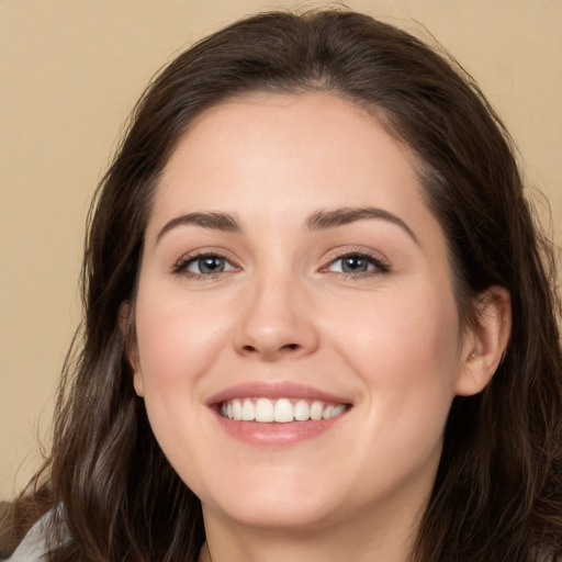 Joyful white young-adult female with long  brown hair and brown eyes