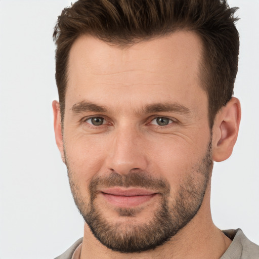 Joyful white young-adult male with short  brown hair and brown eyes