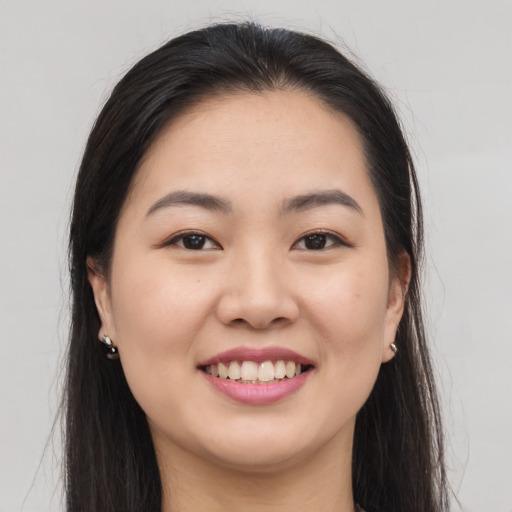 Joyful asian young-adult female with long  brown hair and brown eyes