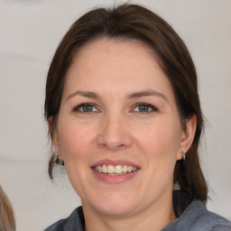 Joyful white adult female with medium  brown hair and grey eyes