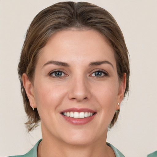 Joyful white young-adult female with medium  brown hair and green eyes