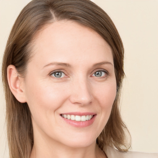 Joyful white young-adult female with long  brown hair and blue eyes