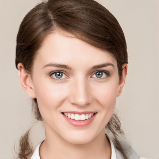 Joyful white young-adult female with medium  brown hair and grey eyes