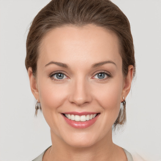 Joyful white young-adult female with medium  brown hair and grey eyes