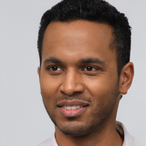 Joyful black young-adult male with short  black hair and brown eyes