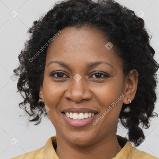 Joyful black young-adult female with long  brown hair and brown eyes