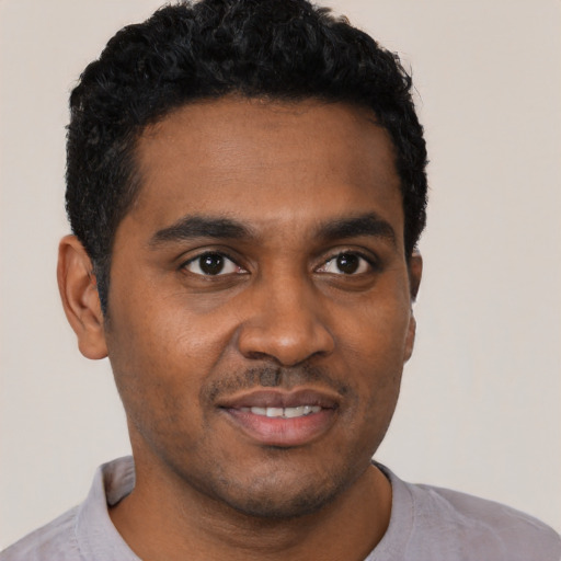 Joyful black young-adult male with short  black hair and brown eyes