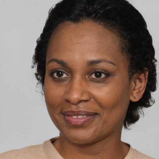 Joyful black adult female with short  black hair and brown eyes