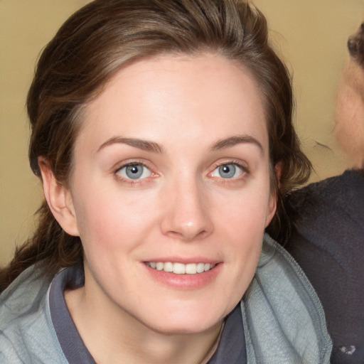 Joyful white young-adult female with medium  brown hair and blue eyes