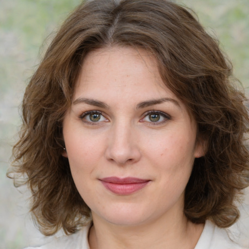 Joyful white young-adult female with medium  brown hair and green eyes