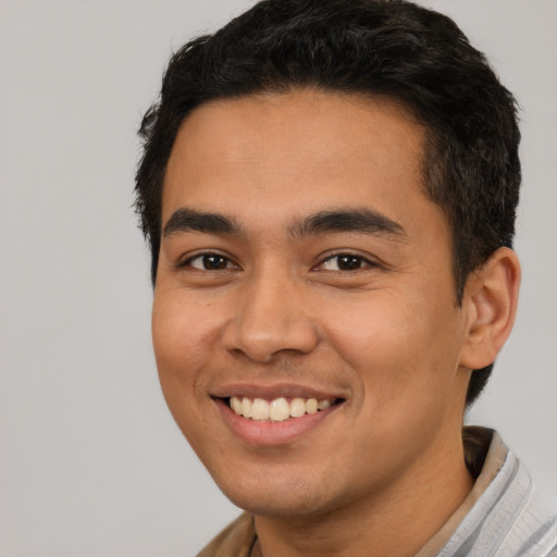 Joyful latino young-adult male with short  brown hair and brown eyes