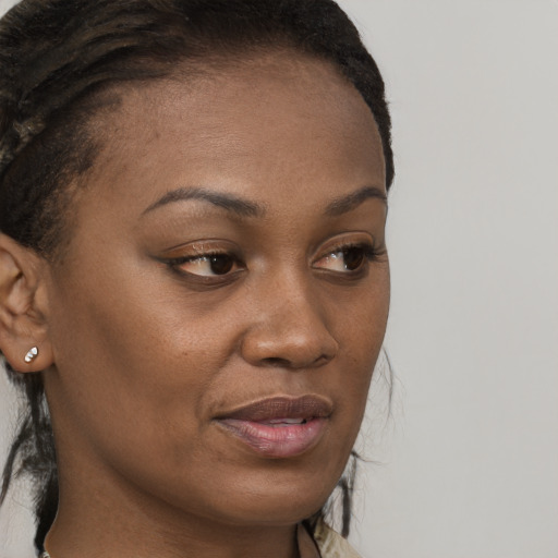 Joyful black young-adult female with long  brown hair and brown eyes