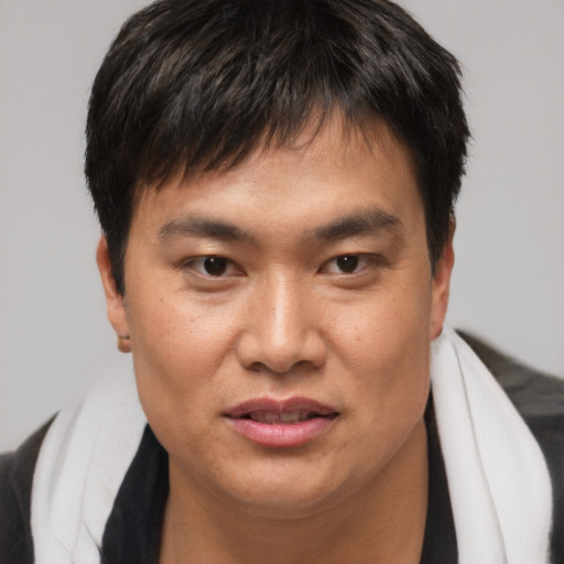 Joyful asian young-adult male with short  brown hair and brown eyes
