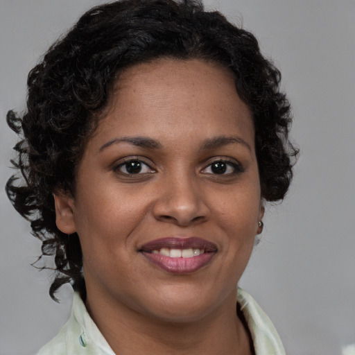 Joyful black young-adult female with medium  brown hair and brown eyes