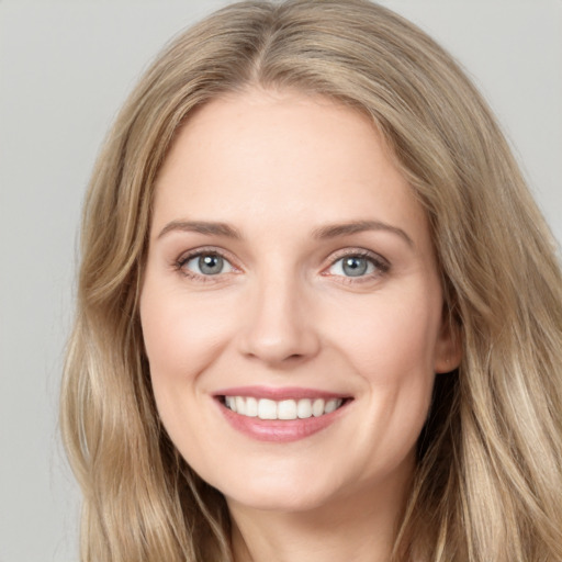 Joyful white young-adult female with long  brown hair and grey eyes