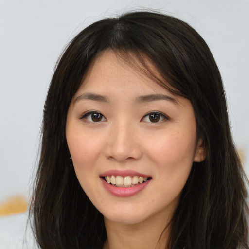 Joyful asian young-adult female with long  brown hair and brown eyes