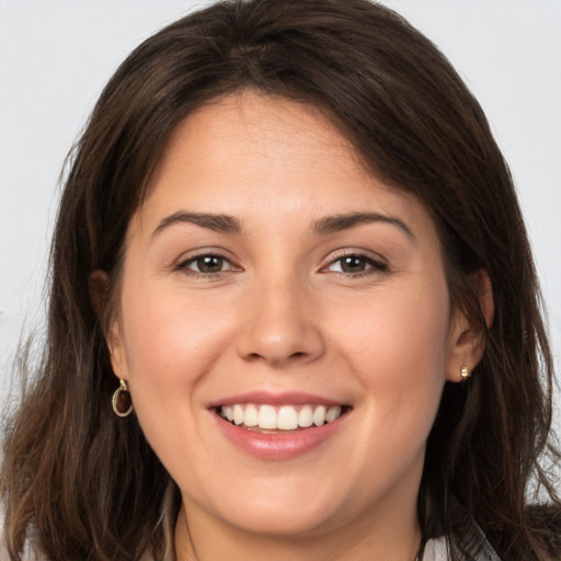 Joyful white young-adult female with long  brown hair and brown eyes