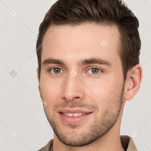 Joyful white young-adult male with short  brown hair and brown eyes