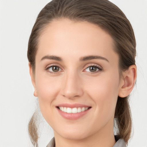 Joyful white young-adult female with medium  brown hair and grey eyes