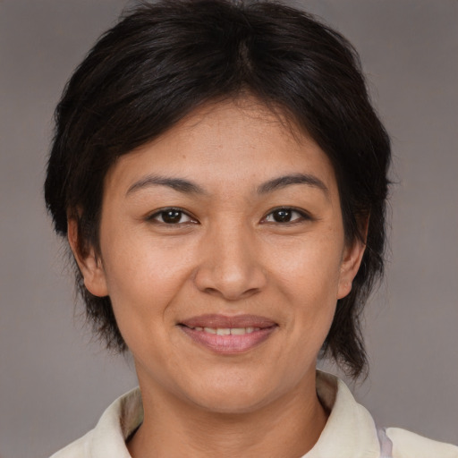 Joyful asian adult female with medium  brown hair and brown eyes
