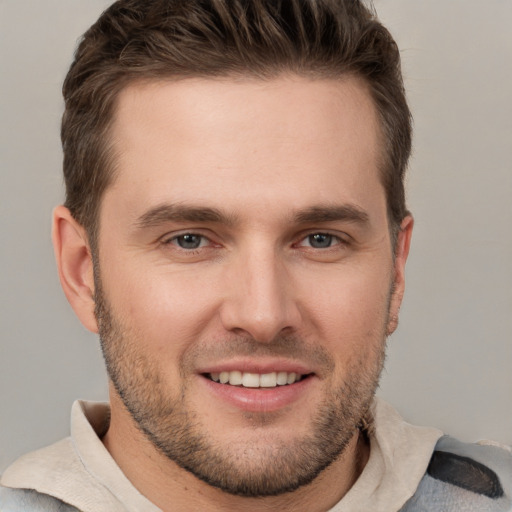 Joyful white young-adult male with short  brown hair and grey eyes