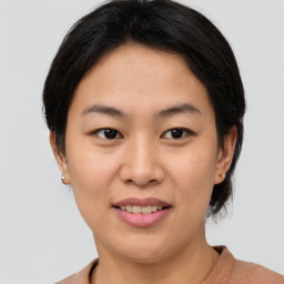 Joyful asian young-adult female with short  brown hair and brown eyes