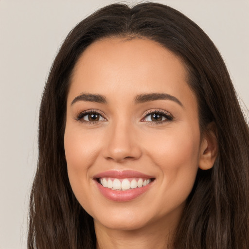 Joyful white young-adult female with long  brown hair and brown eyes