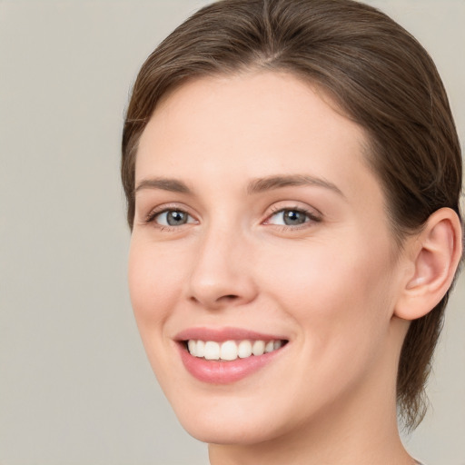 Joyful white young-adult female with medium  brown hair and grey eyes