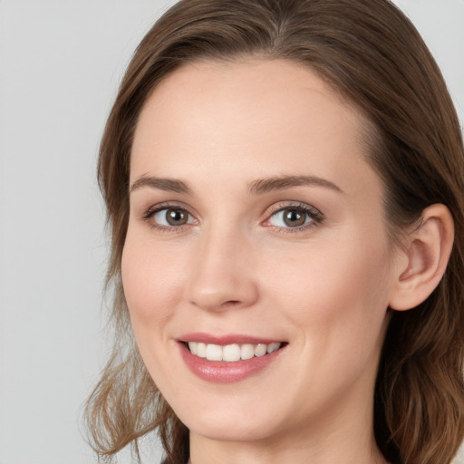 Joyful white young-adult female with long  brown hair and blue eyes