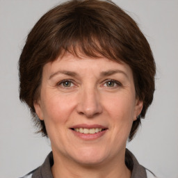 Joyful white adult female with medium  brown hair and grey eyes