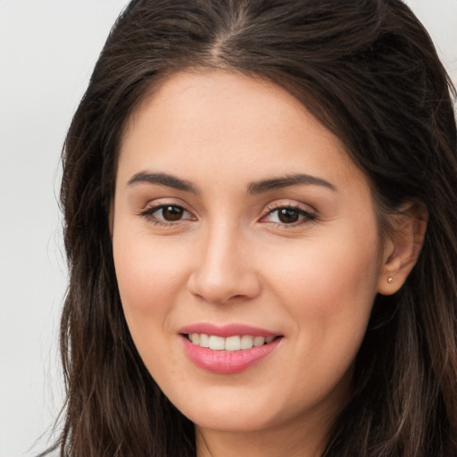 Joyful white young-adult female with long  brown hair and brown eyes