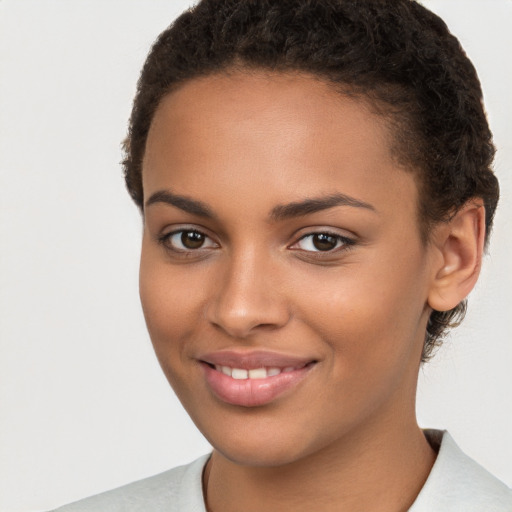 Joyful black young-adult female with short  brown hair and brown eyes