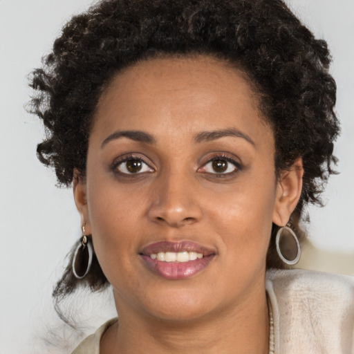 Joyful black young-adult female with short  brown hair and brown eyes