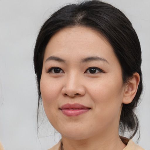 Joyful asian young-adult female with medium  brown hair and brown eyes