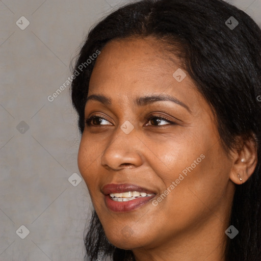 Joyful black adult female with long  black hair and brown eyes