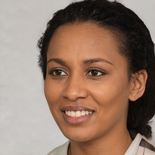 Joyful black young-adult female with medium  brown hair and brown eyes