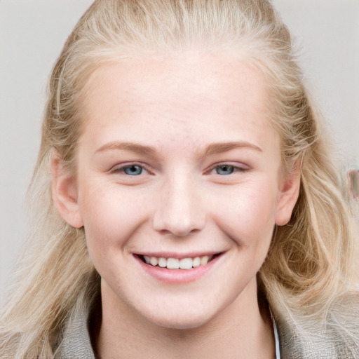 Joyful white young-adult female with long  brown hair and blue eyes